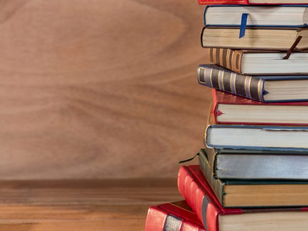 Stack of various books on a wooden table