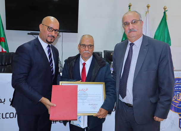 تَكْرِيمُ البُرُوفِيسُورِ مُؤَذِّن قَادَة خِلَالَ اليَوْمِ العِلْمِيِّ الوَطَنِيِّ الأَوَّل